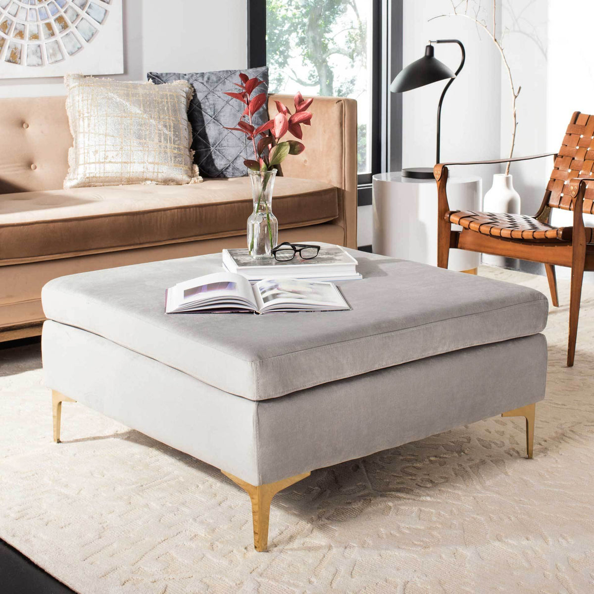 A generous gray velvet top offers inviting comfort and display space above slender brass-finished legs.