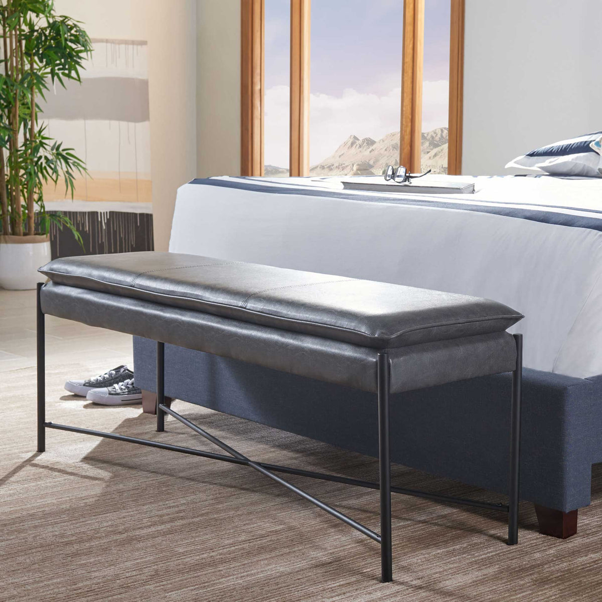 Gray bench brings cushioned comfort and minimalist black metal lines to the foot of a bed