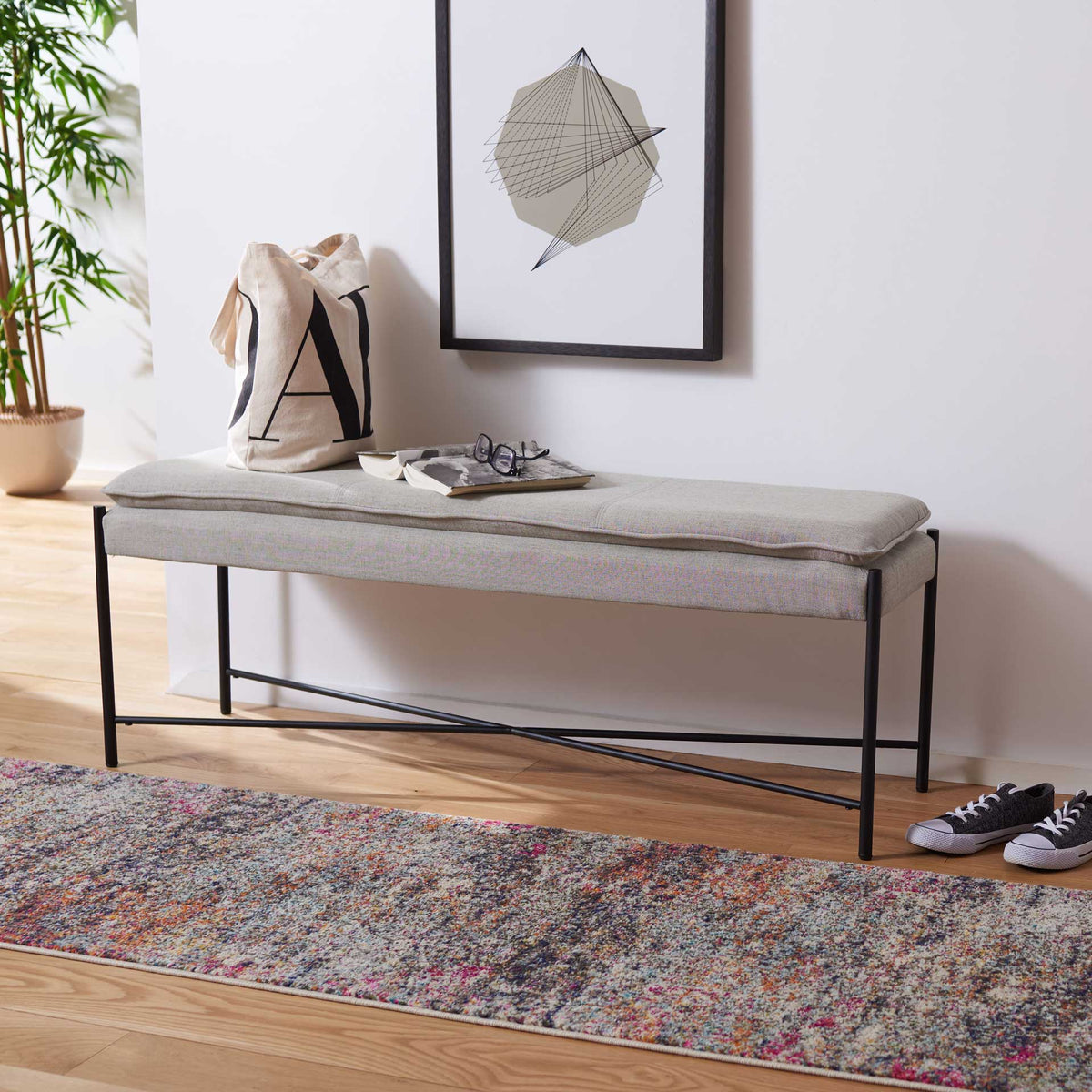 Light gray linen bench adds tailored seating and an airy black metal frame to a bright space