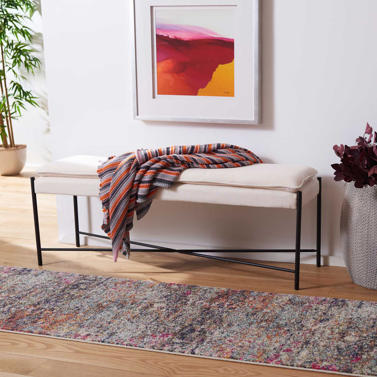 Light beige linen bench provides soft seating with sleek black X-braced legs