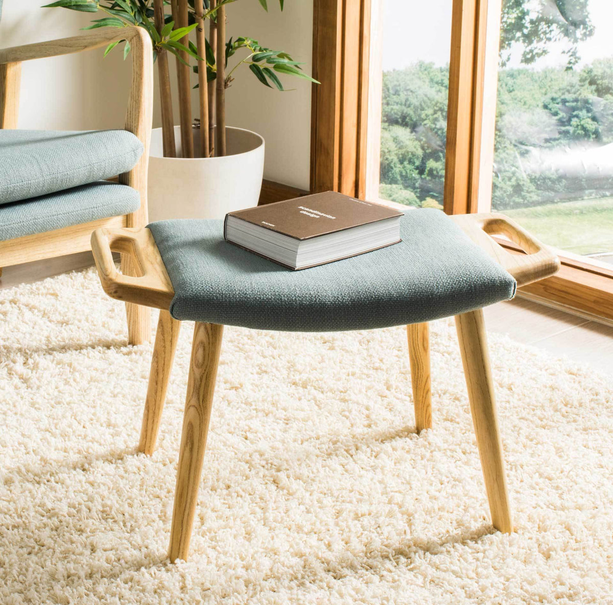 Blue upholstery and natural wood handles lend an inviting touch to this low bench by the window.