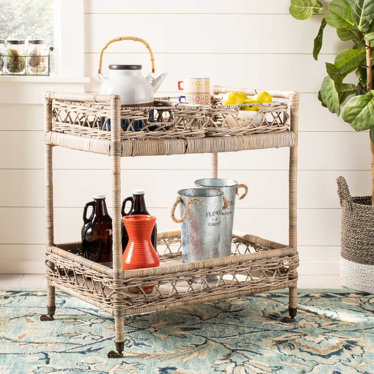 Two tiers of woven storage keep drinks and serving pieces close at hand on a rolling rattan cart.