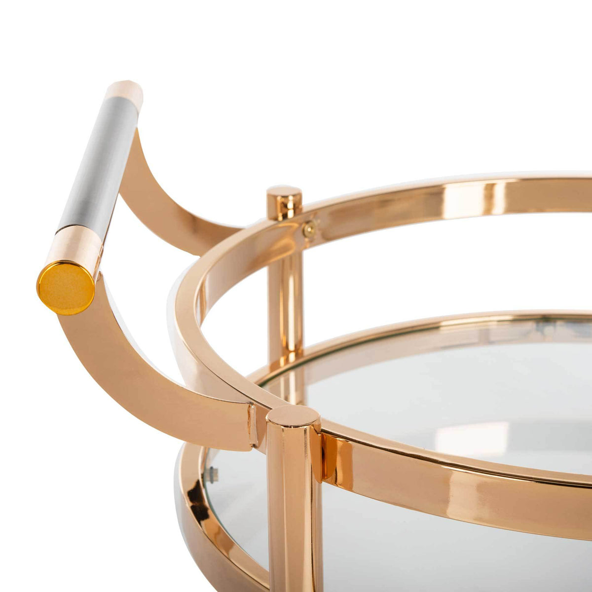 A curved gold handle with a contrasting grip meets the raised rim of a clear glass tray