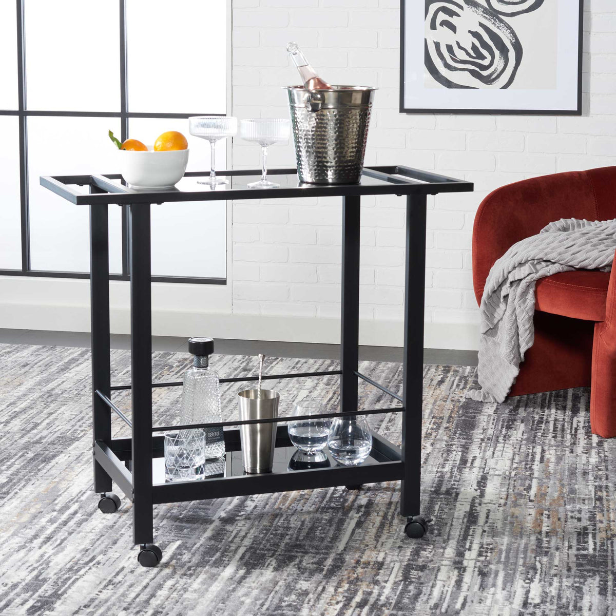 Serve drinks with ease on a matte black bar cart with open handles, glass tiers, and rolling casters.