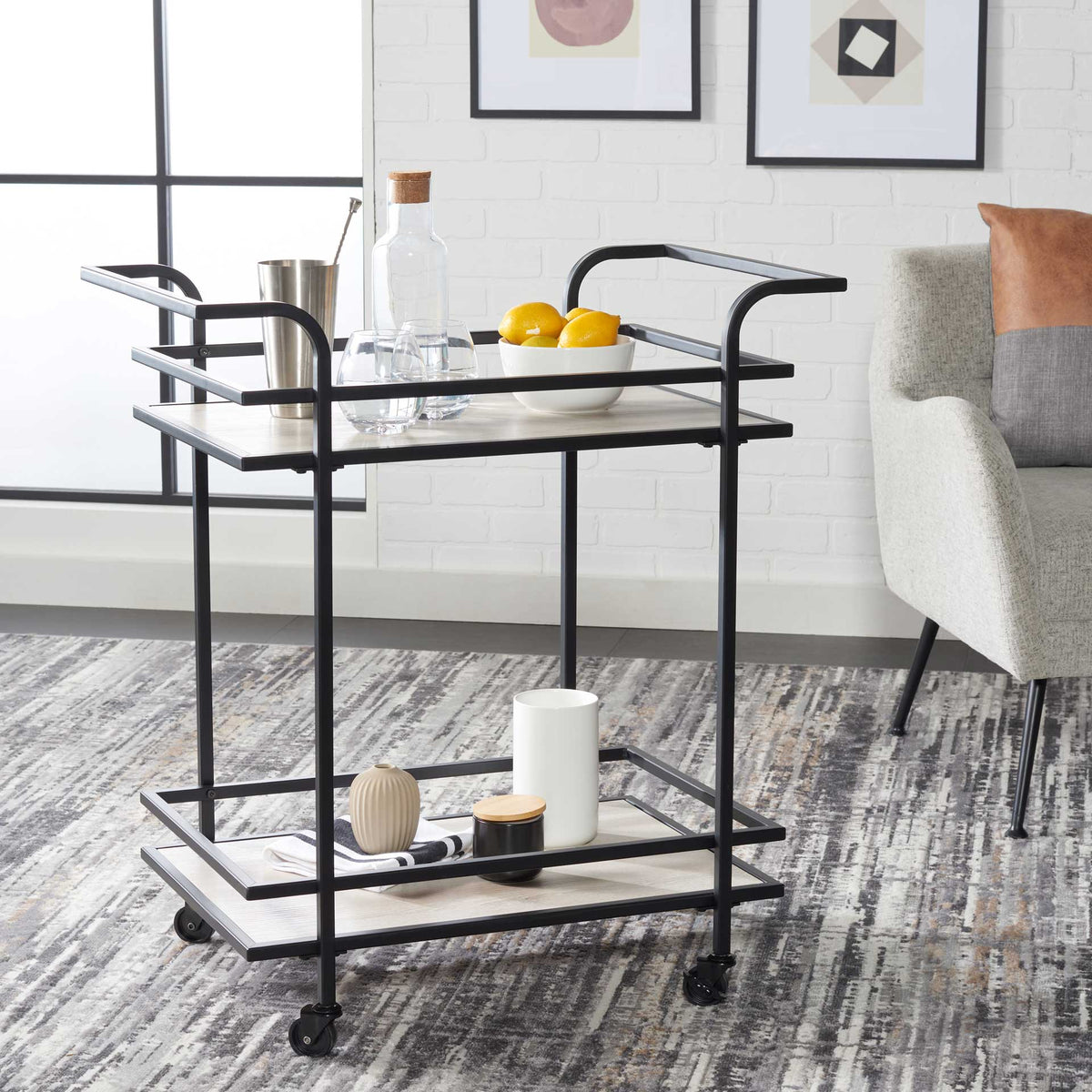 Matte black bar cart holds glassware and accents across two roomy gray shelves.
