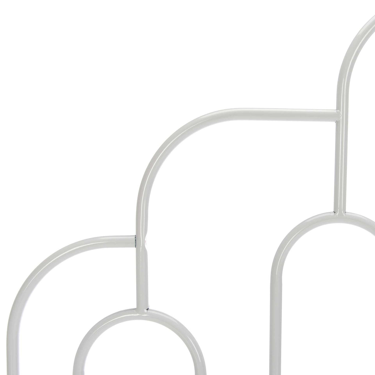 White tubular metalwork pairs cascading arches with elongated oval motifs