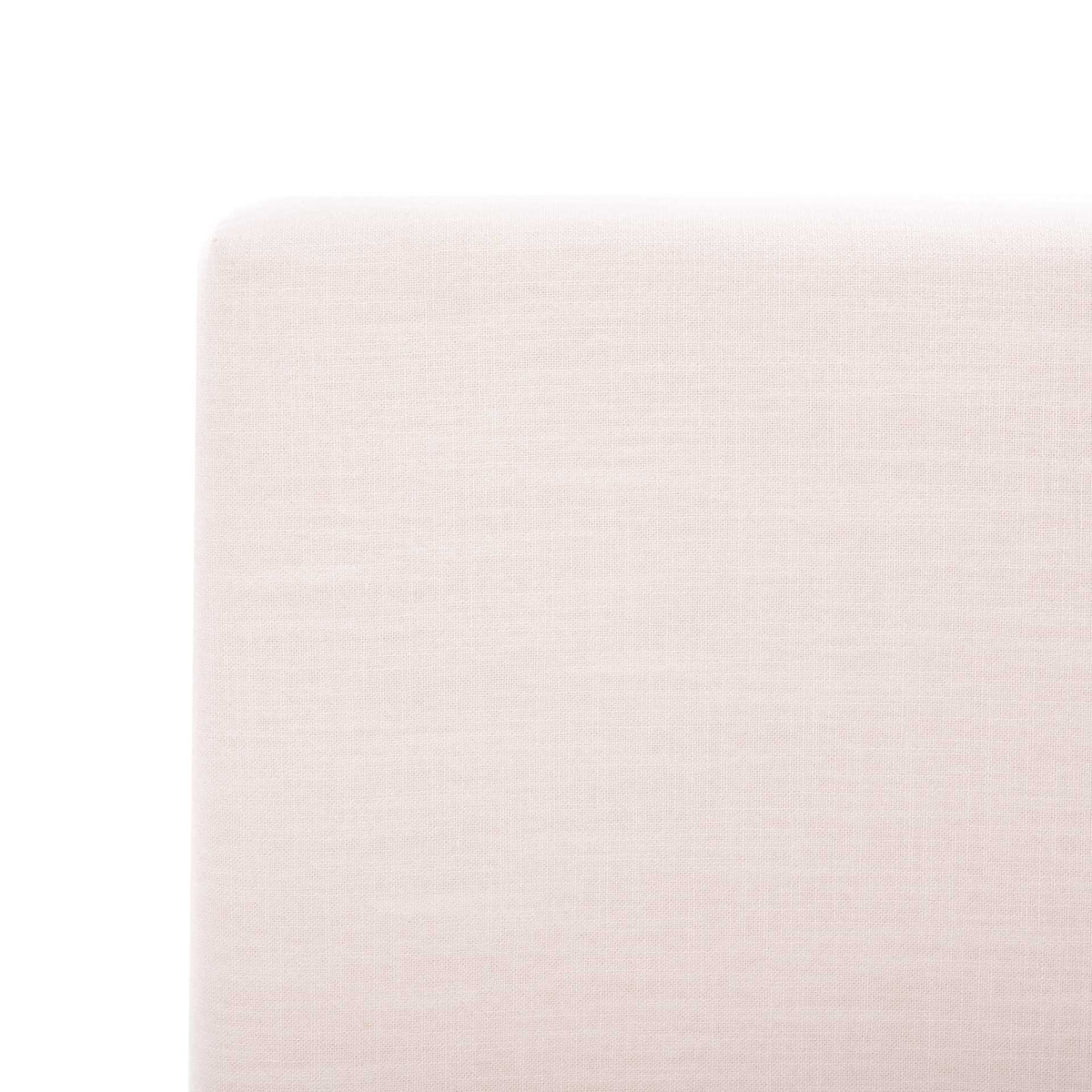 Fine light beige linen wraps the headboard's gently rounded corner