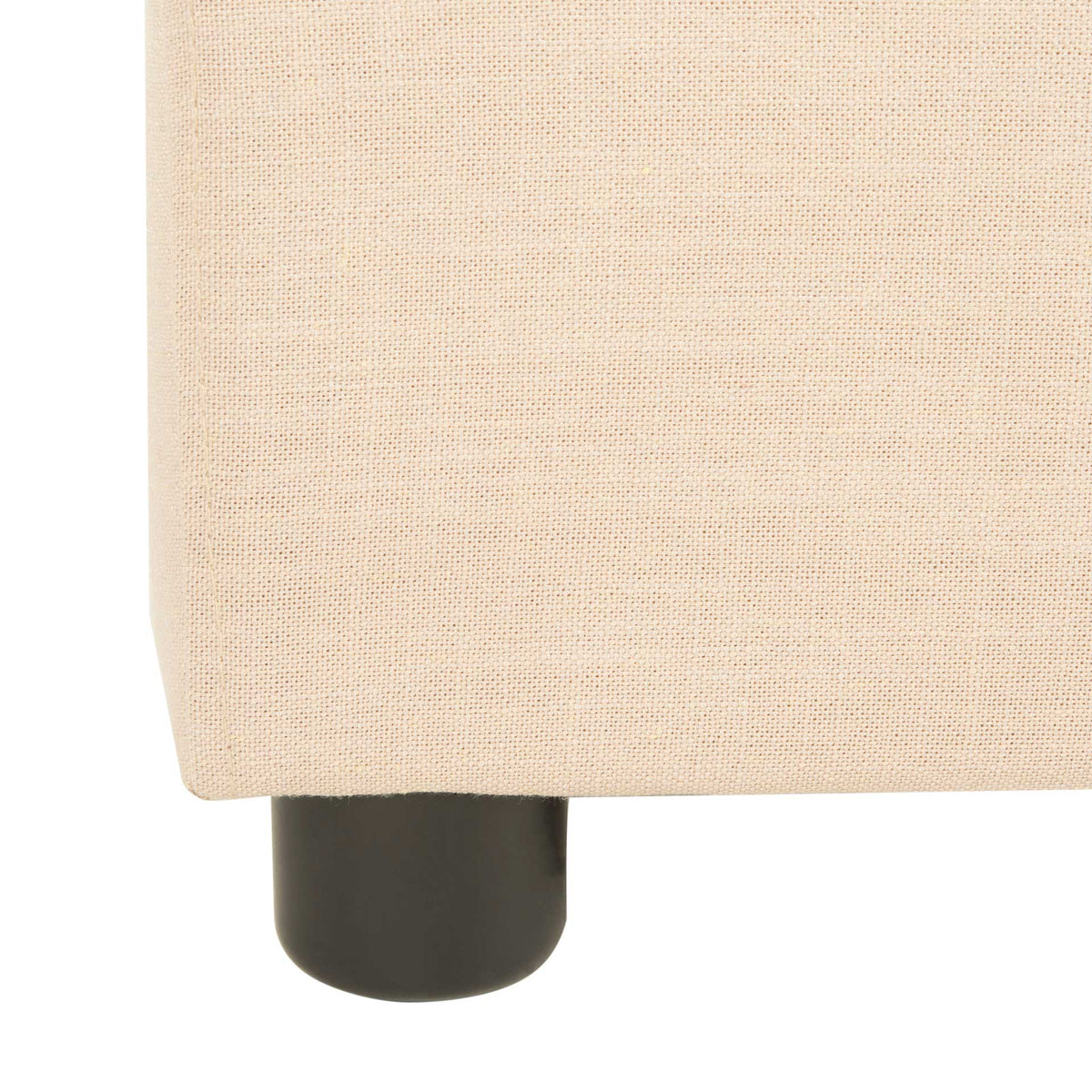 A compact black cylindrical foot adds contrast beneath the beige upholstered bed frame