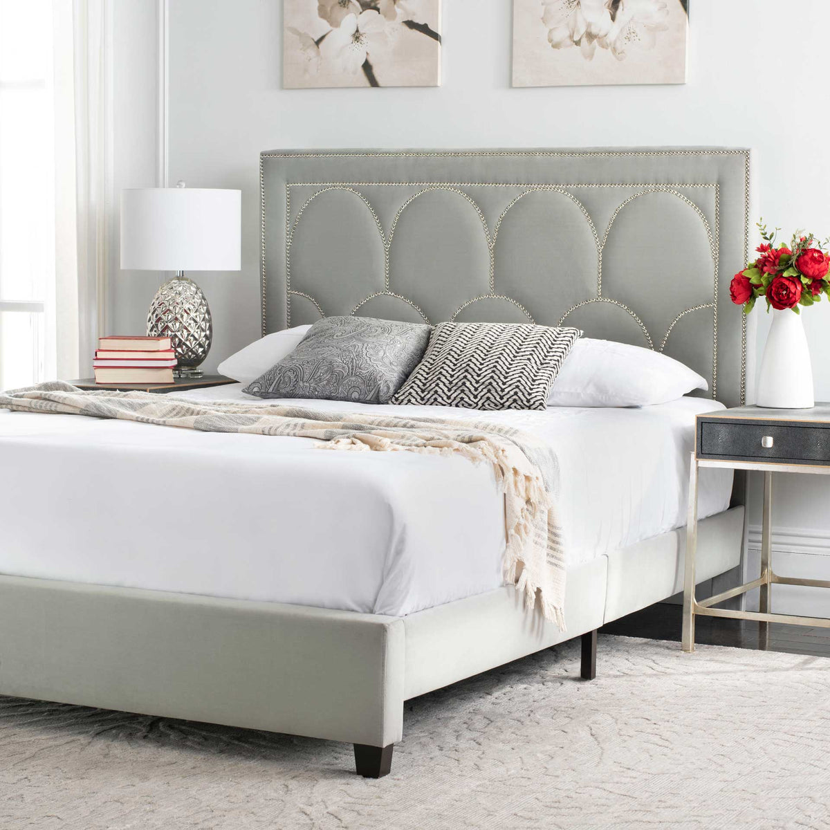 Tailored gray velvet and an ornate headboard bring understated glamour to the bedroom