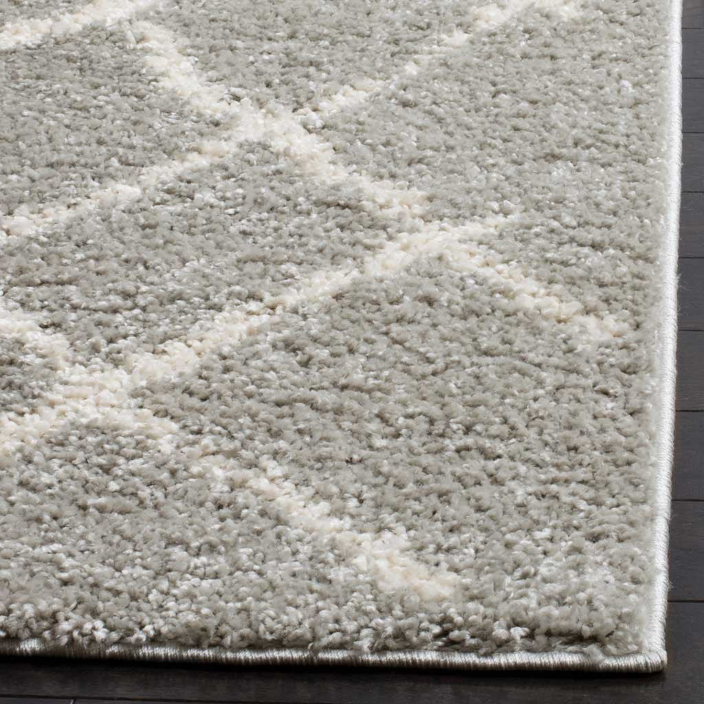 Soft cream diamond lines cross thick gray shag above a neatly finished edge