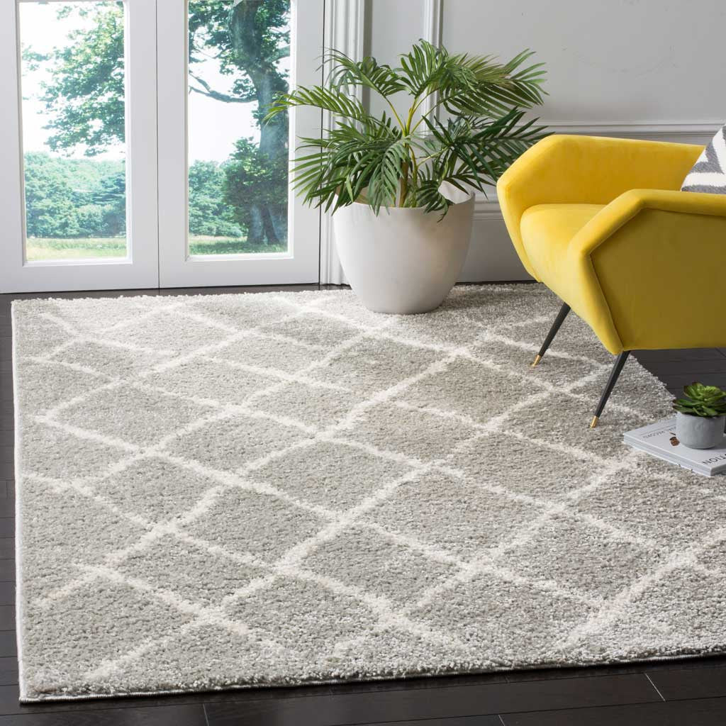 Light gray shag rug with creamy diamond lines softens the space beside a yellow chair