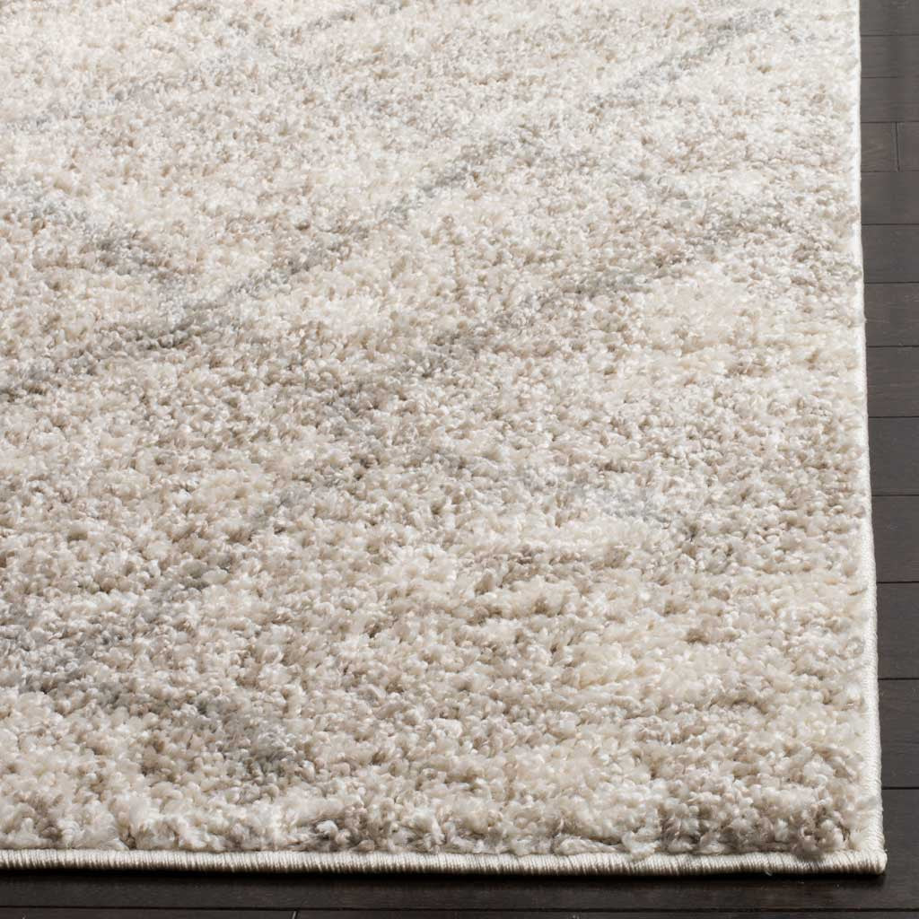Deep cream and gray shag fibers meet a neatly finished rug edge