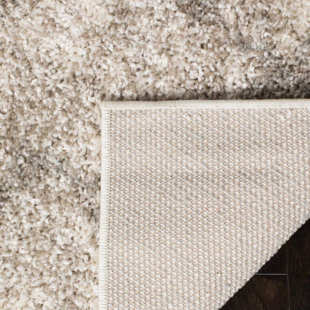 Plush cream and light gray shag folds back to reveal its tightly woven underside