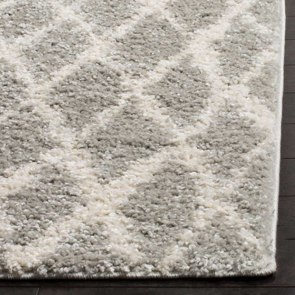 A plush gray and cream diamond motif continues to the rug's neatly finished corner.