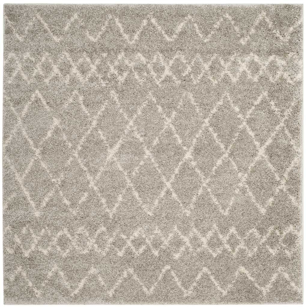 Square light gray shag rug features cream diamonds and decorative zigzag bands