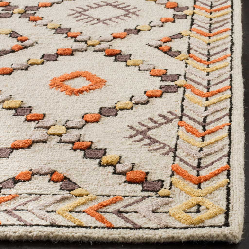 Raised orange and golden motifs add texture to ivory wool pile beside a chevron-patterned edge.