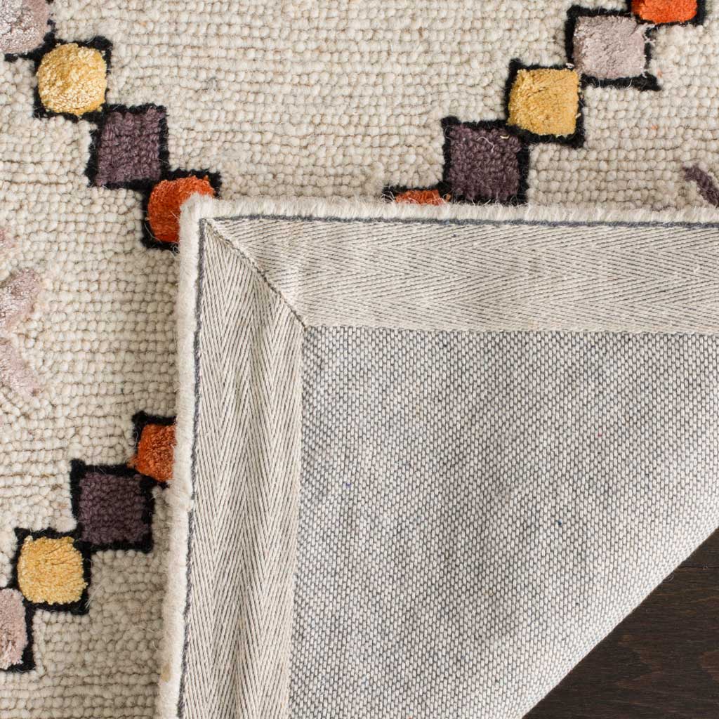 Colorful geometric wool pile meets a neatly bound edge and sturdy woven backing.