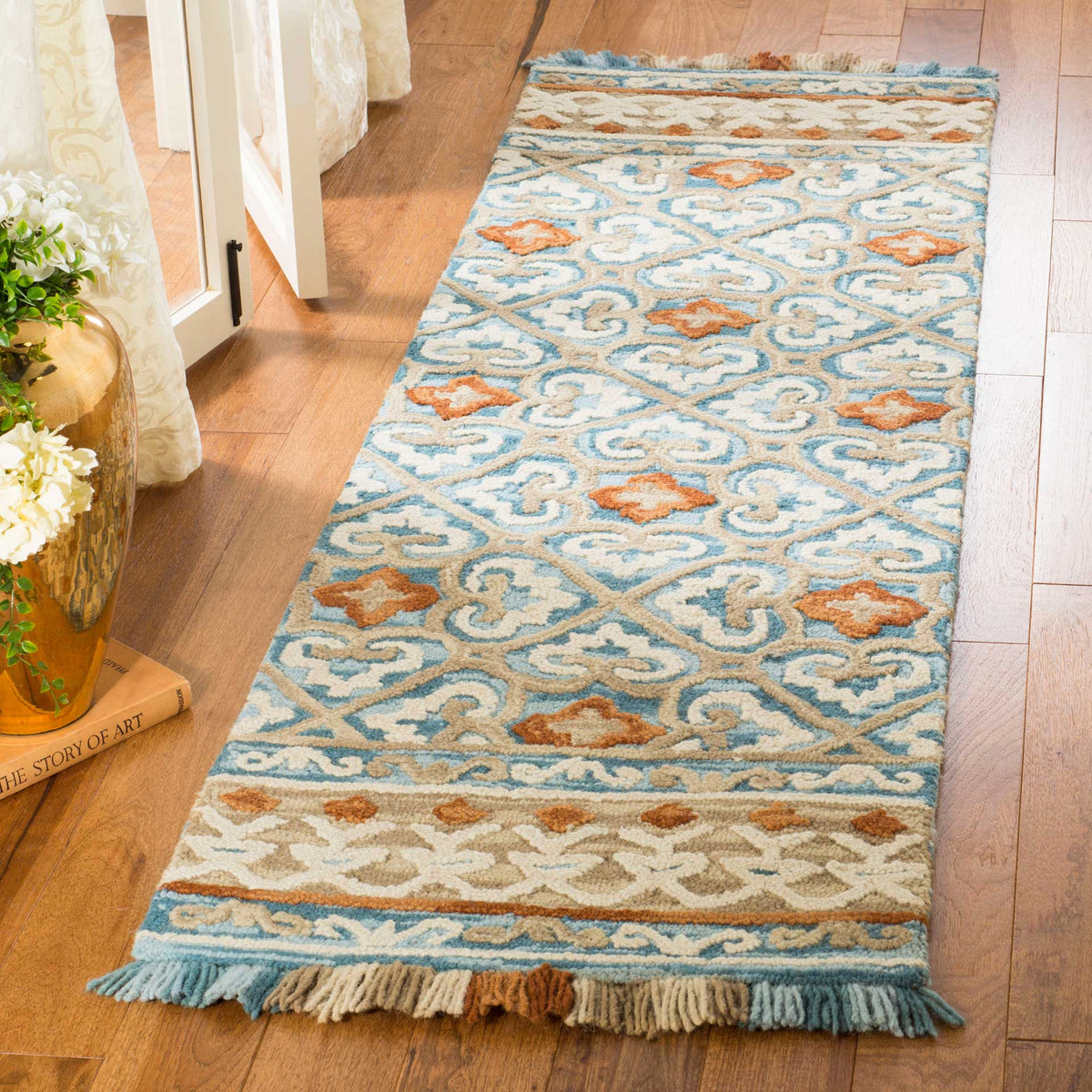 Textured ivory and blue runner with warm rust motifs and multicolored fringe