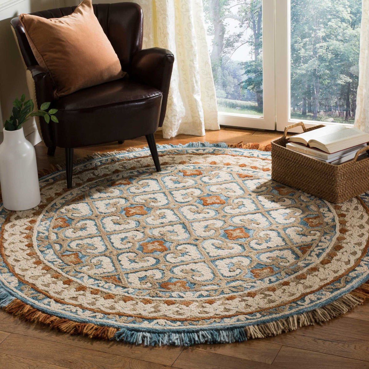 An ornate ivory and blue rug with rust accents and fringe warms a relaxed seating area