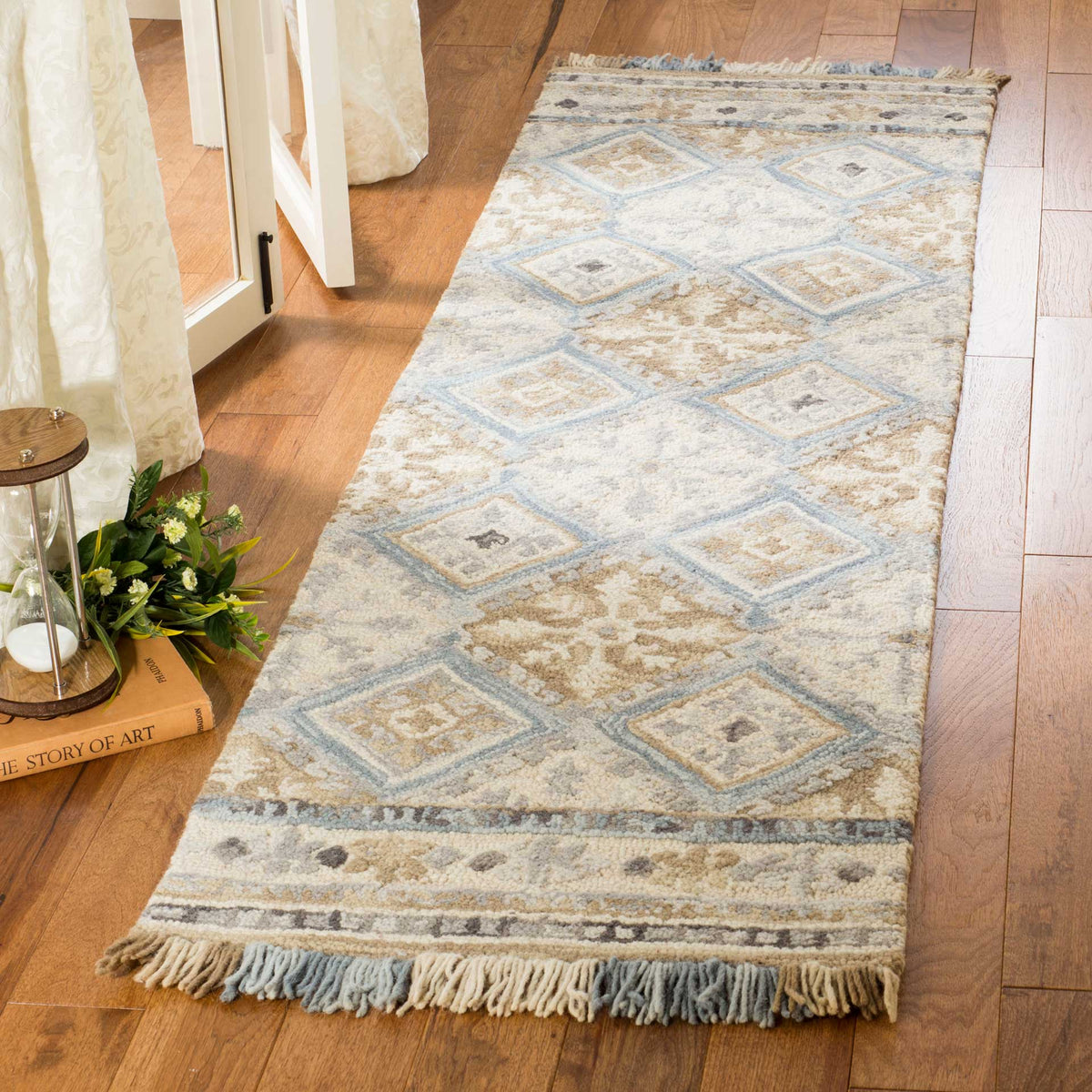 Soft beige and light blue runner pairs floral motifs with repeating diamonds and fringed ends
