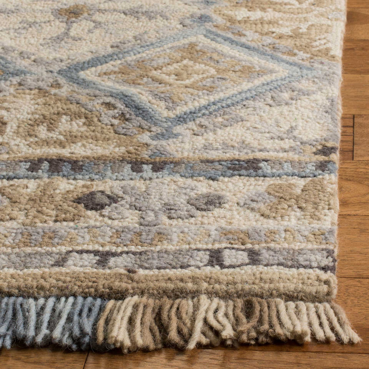 Plush beige pile and light blue diamond outlines meet a detailed border and soft, two-tone fringe.