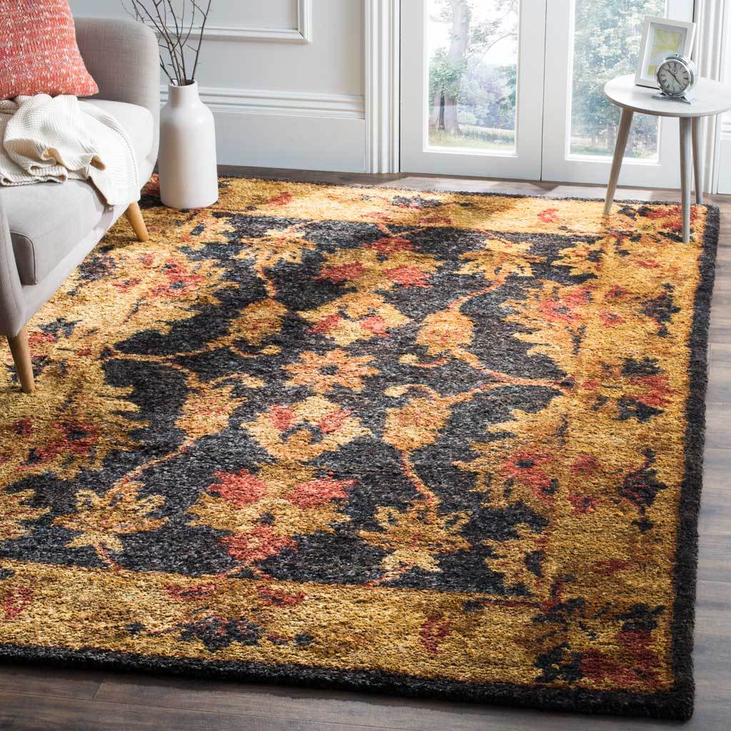 Ornate charcoal and gold floral rug grounds a bright living room with warm rust accents