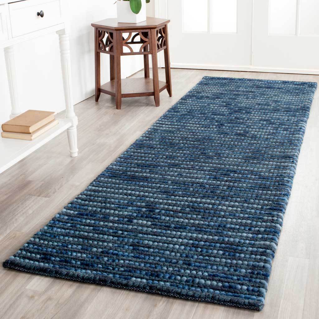 A dark blue runner anchors the floor with closely woven rows and tonal depth
