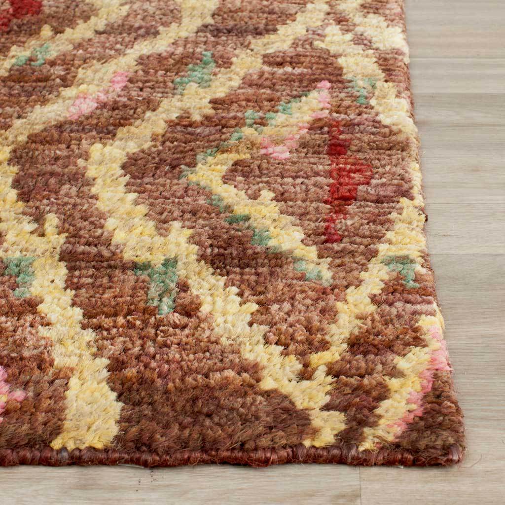 A bound edge frames chunky brown texture, gold zigzags, and red, pink, and teal accents