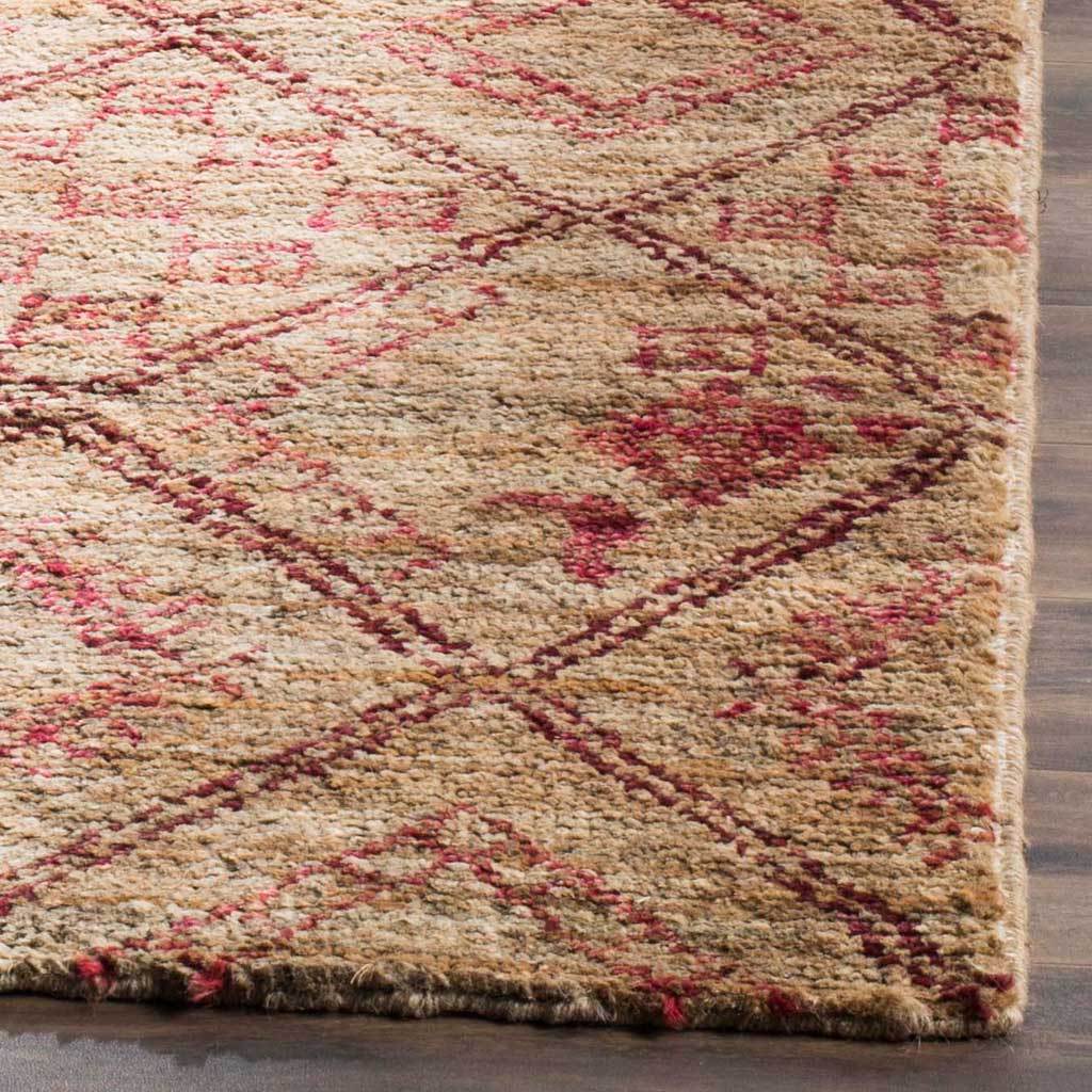 Natural fibers and red motifs frame the textured edge of this hand-knotted geometric rug.
