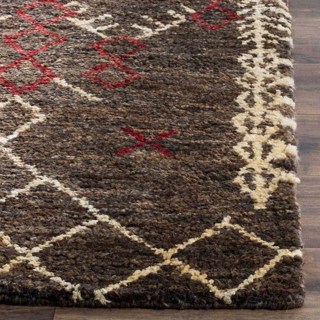 Textured brown fibers meet cream geometric borders and red motifs at a finished edge