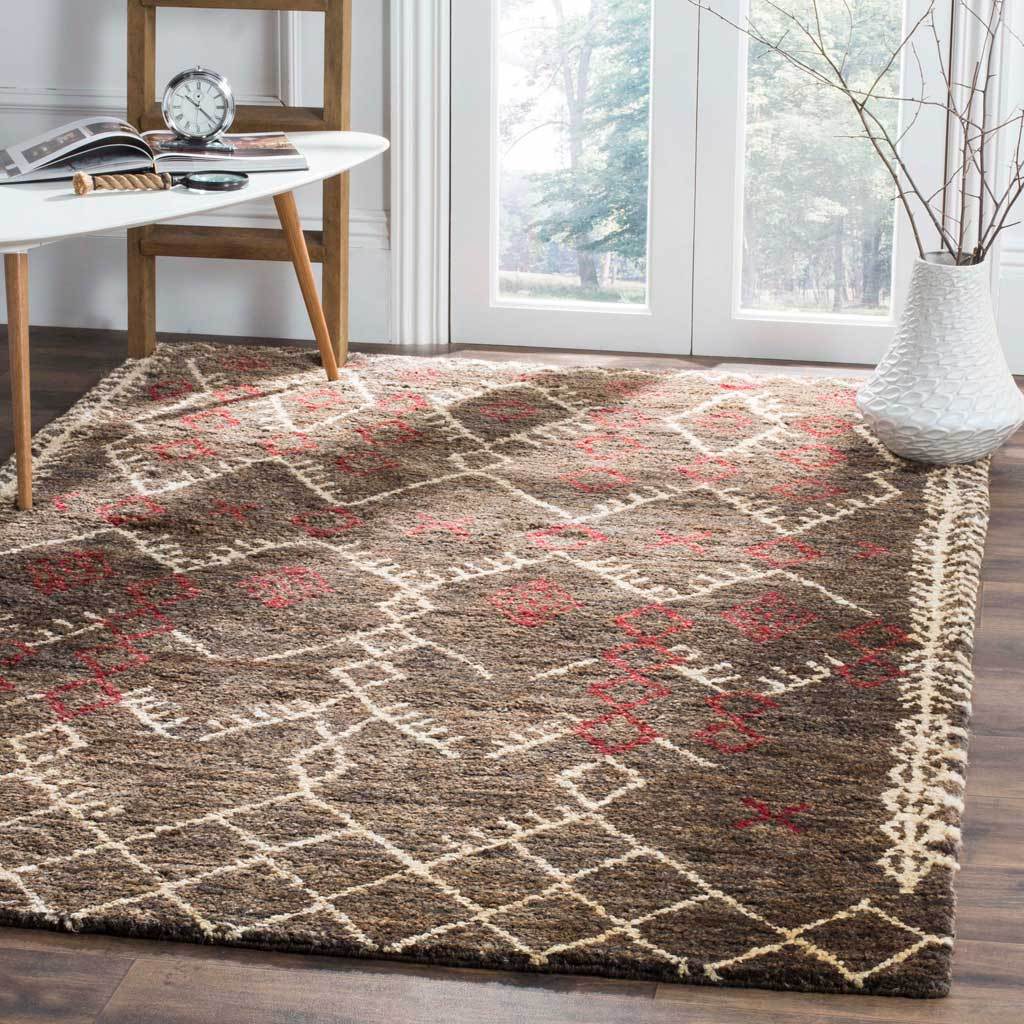 Earthy brown geometric rug brings warm red motifs and ivory latticework to a bright room