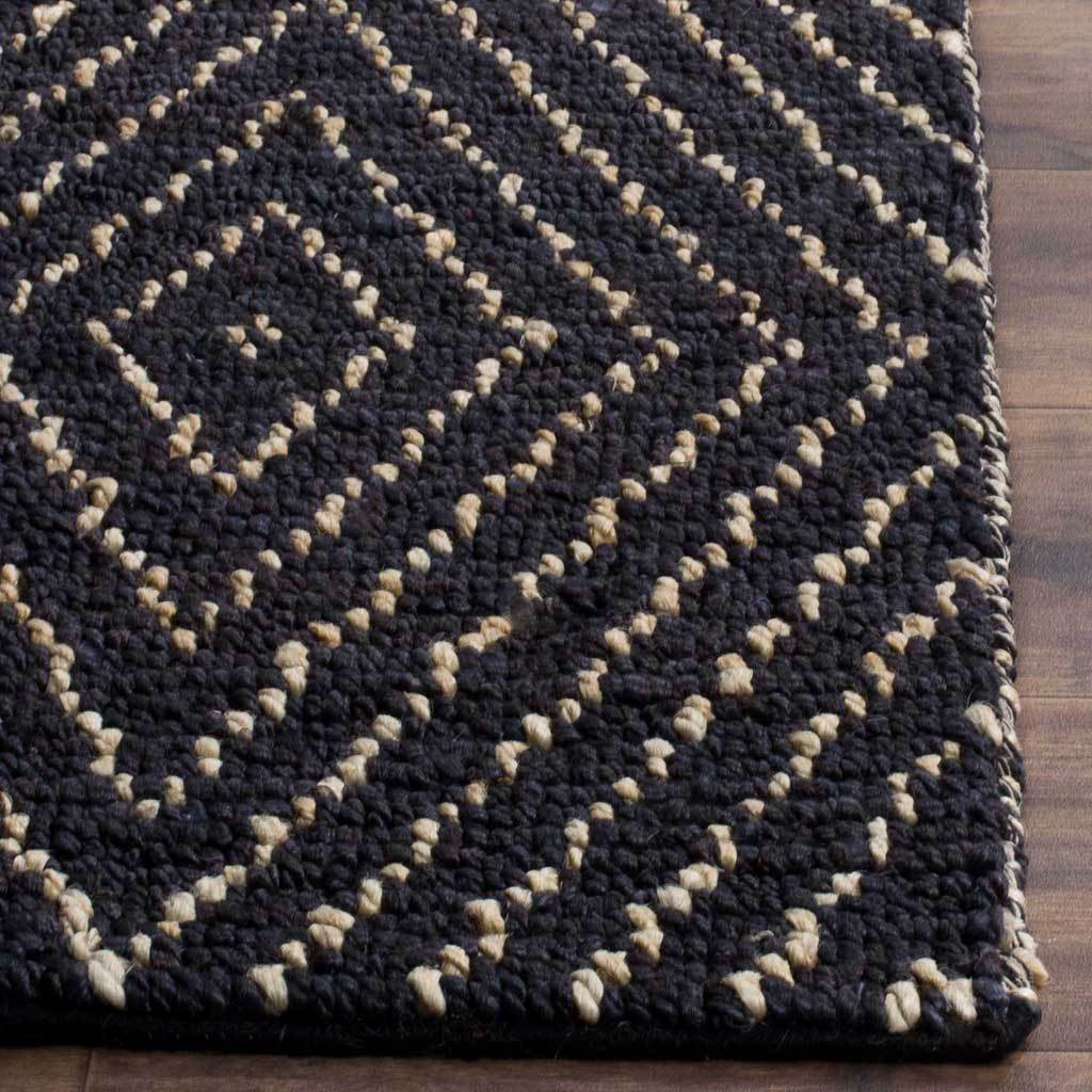 Chunky black and ivory yarns trace geometric diamonds along the rug's finished edge