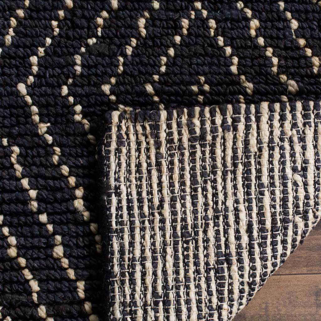Turned rug edge reveals a woven backing beneath the textured diamond pattern
