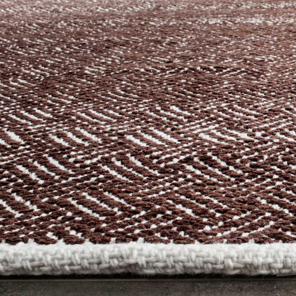 Brown and ivory woven texture meets a thick ivory-bound edge on this cotton rug.