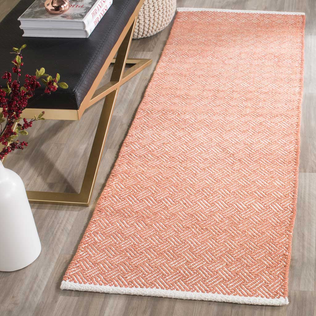 Warm orange chevrons and bright ivory borders enliven this slender woven runner.