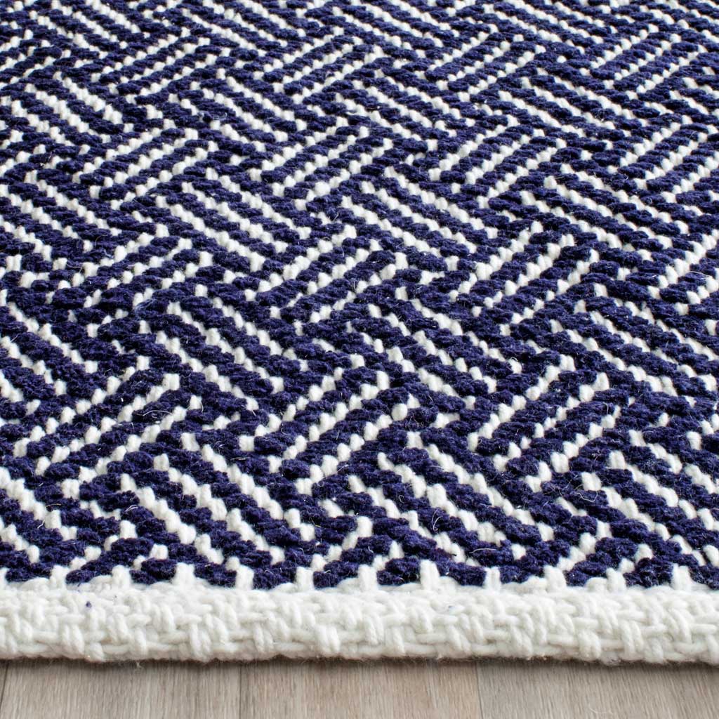 Navy and ivory cotton yarns form dense zigzags above a thick woven edge.