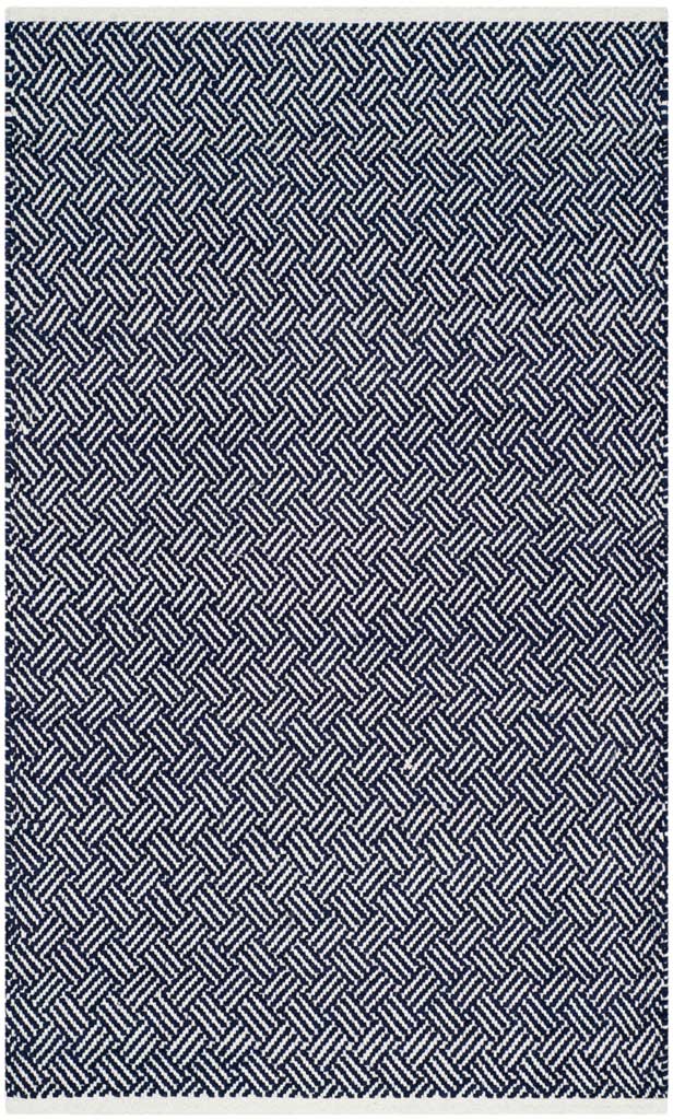 A compact rectangular rug repeats a bold navy and ivory geometric weave from edge to edge.