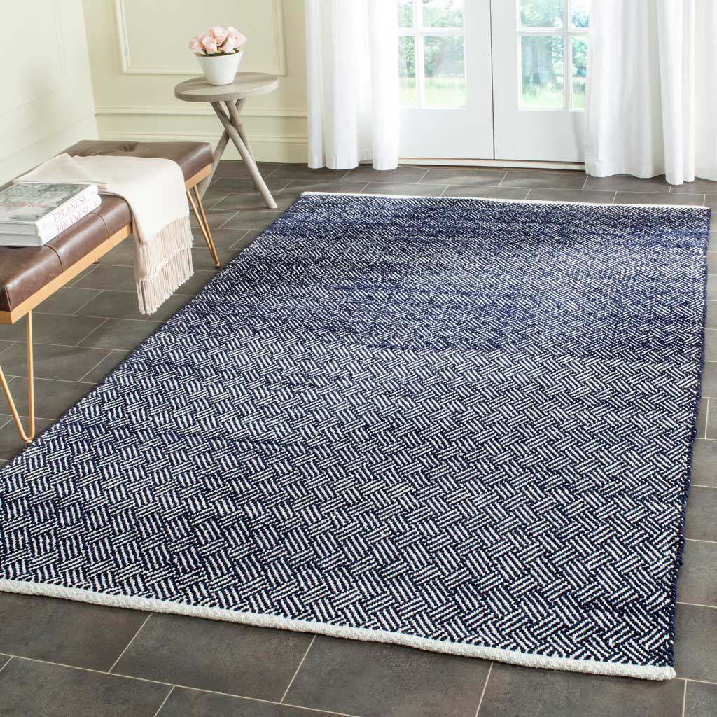 A navy and ivory herringbone rug grounds the room with rhythmic pattern and crisp white edging.
