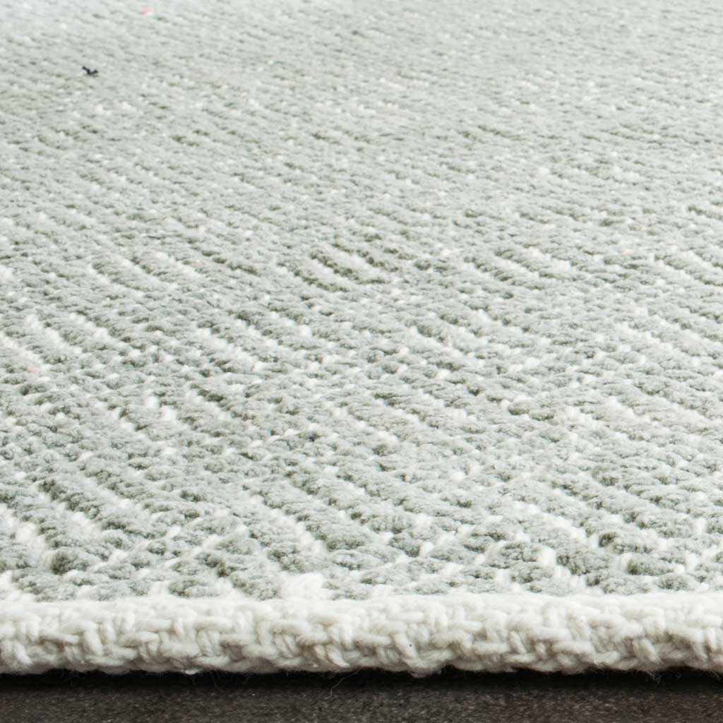 Soft gray cotton loops and an ivory-bound edge bring subtle texture to this woven rug.