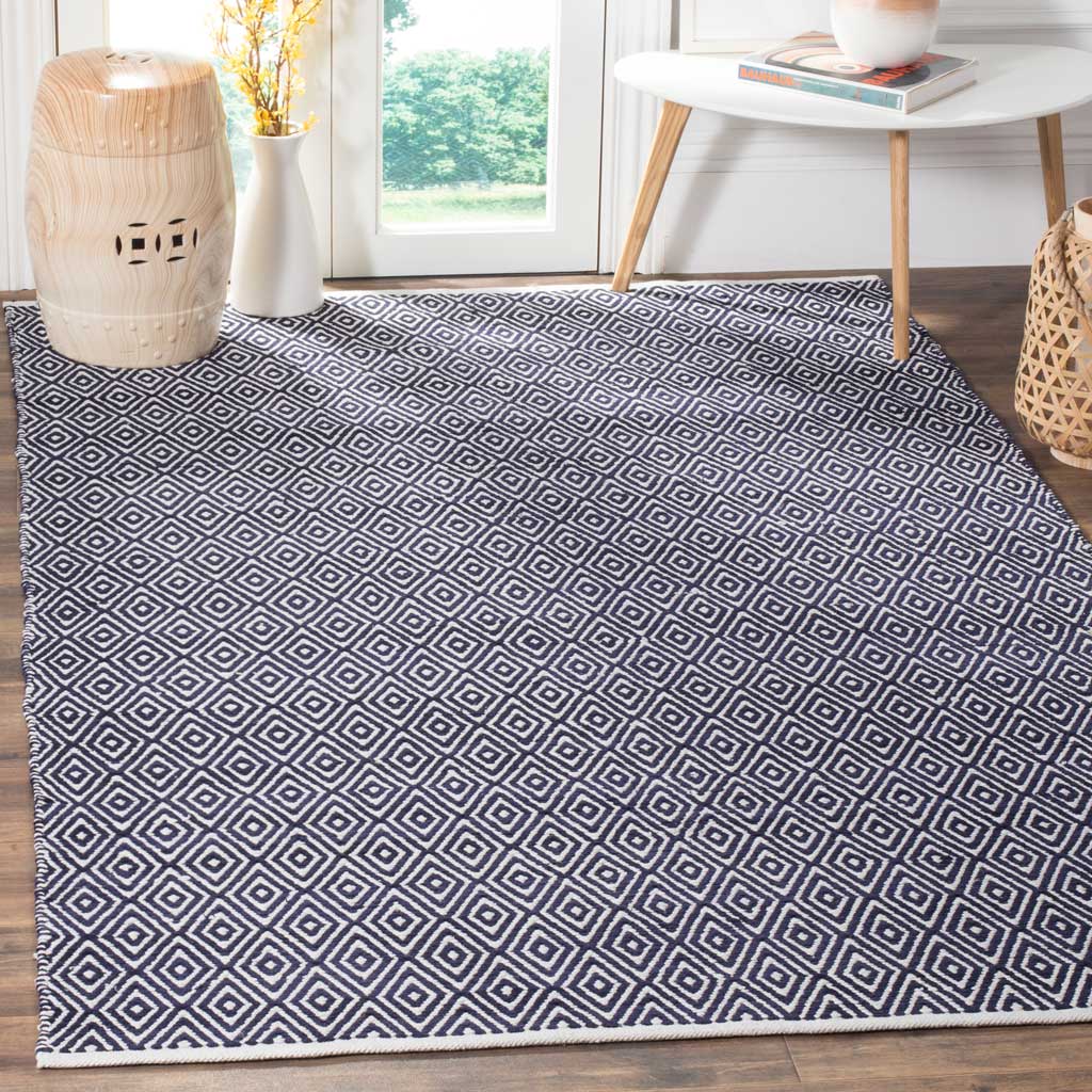 Deep navy and ivory diamonds anchor a bright living area with graphic texture.