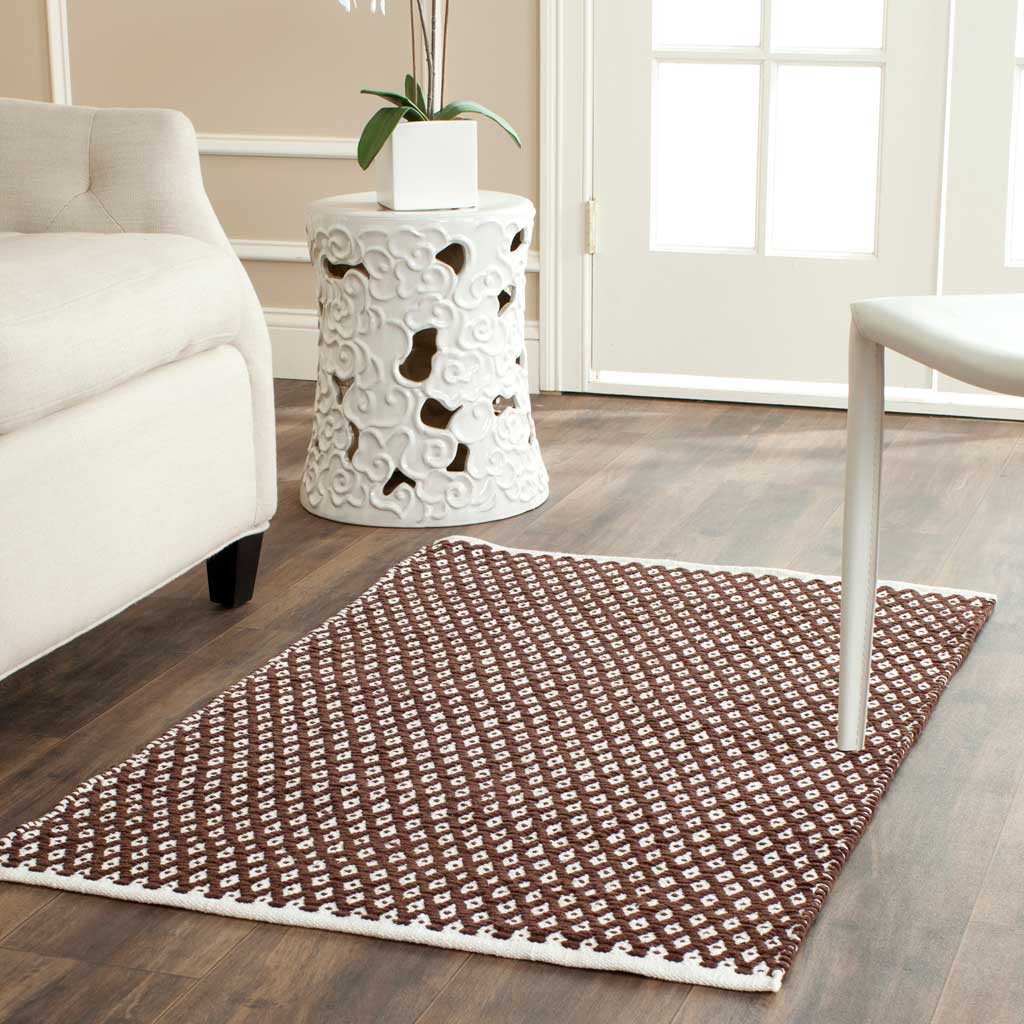 A compact brown diamond-pattern rug lends cozy texture beside a chair and table.