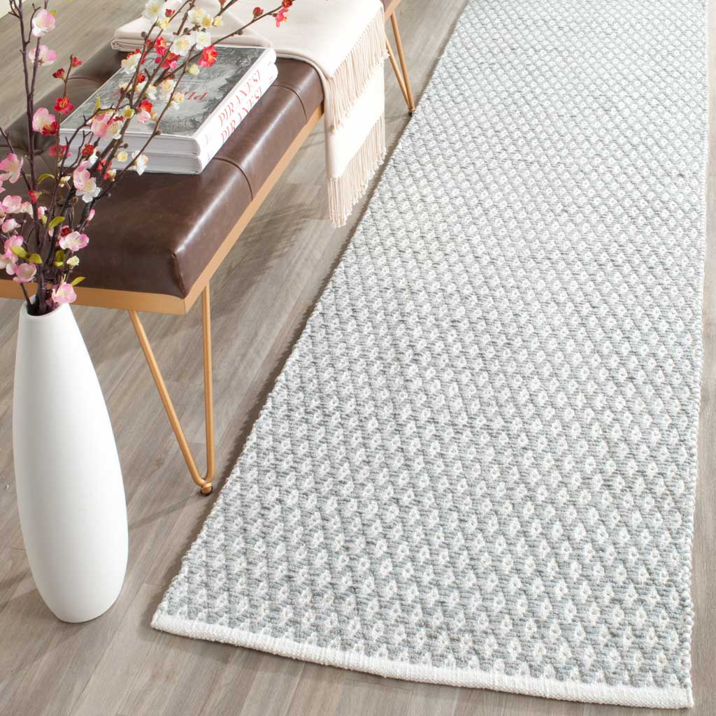 Soft gray geometric motifs give this cotton runner a light, airy feel