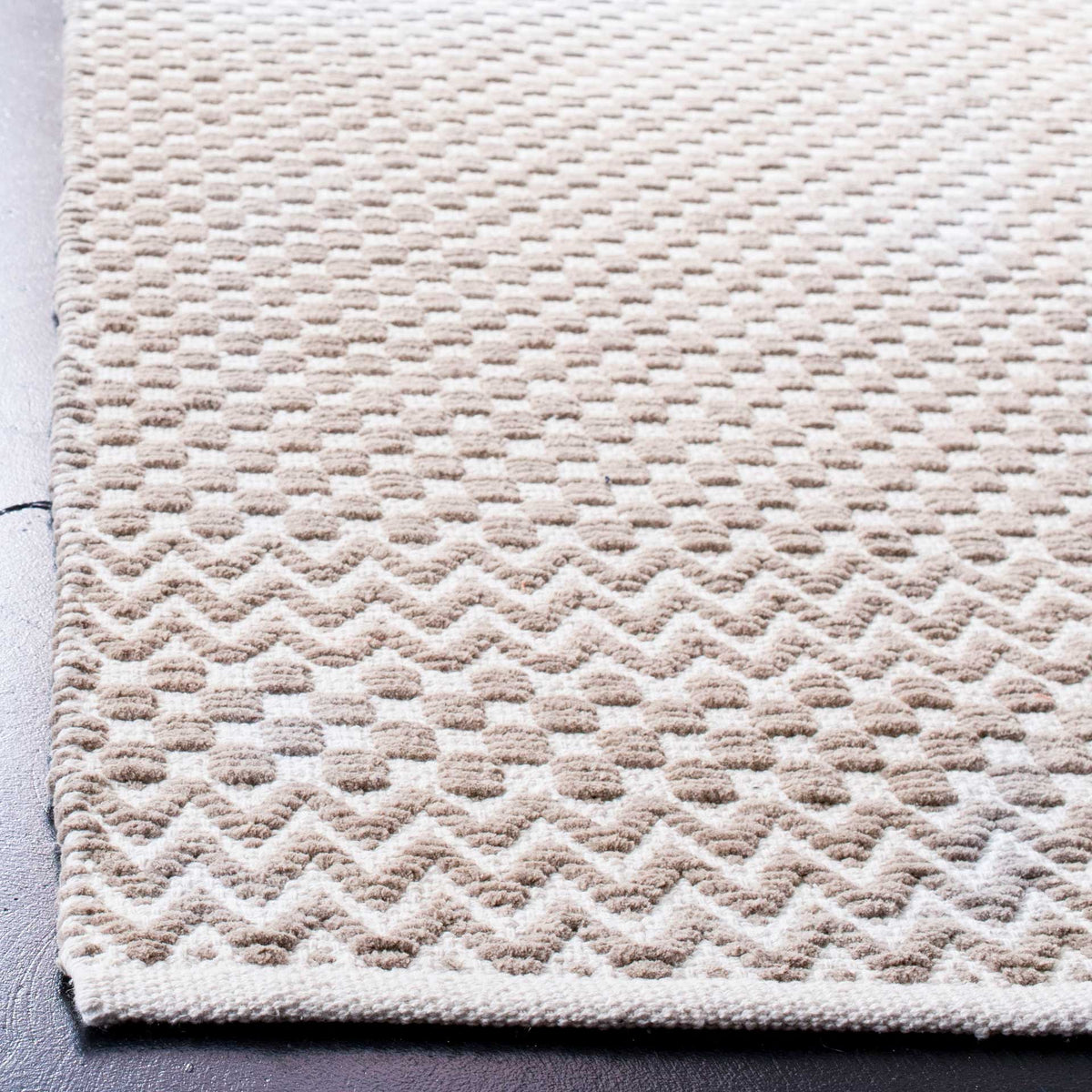 Taupe cotton rug with soft raised checks, chevron bands, and a neatly finished edge