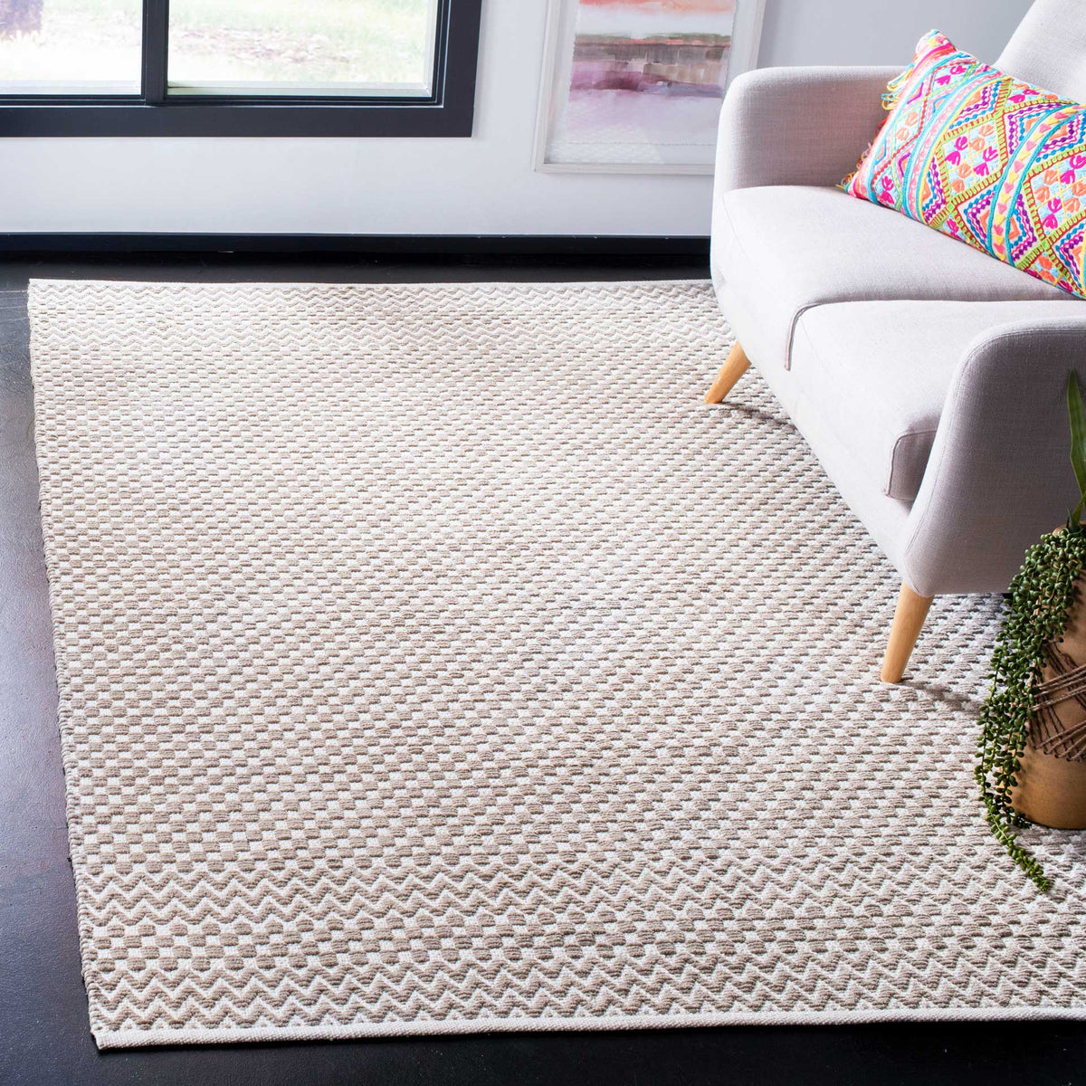 Taupe and ivory geometric rug lends warm woven texture to a bright, relaxed living space