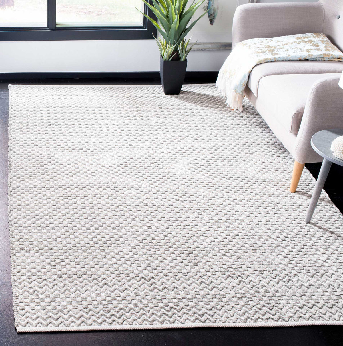 Pale gray cotton rug adds subtle checkered texture and zigzag accents to a bright living area