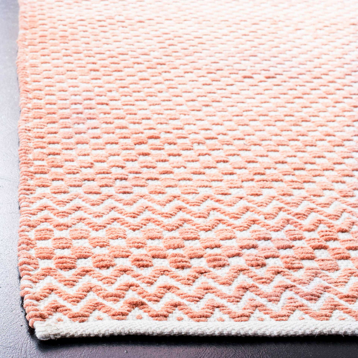 Orange cotton rug combines raised checkerboard texture with zigzag bands and a finished edge