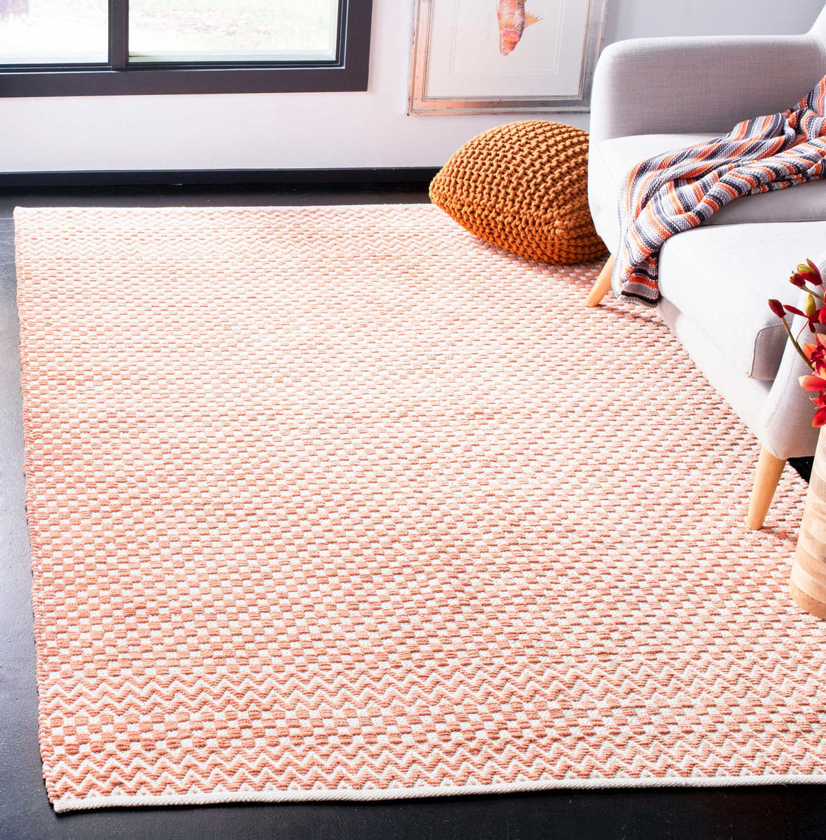 Orange and ivory cotton rug adds lively checkered texture and zigzag accents to a seating area