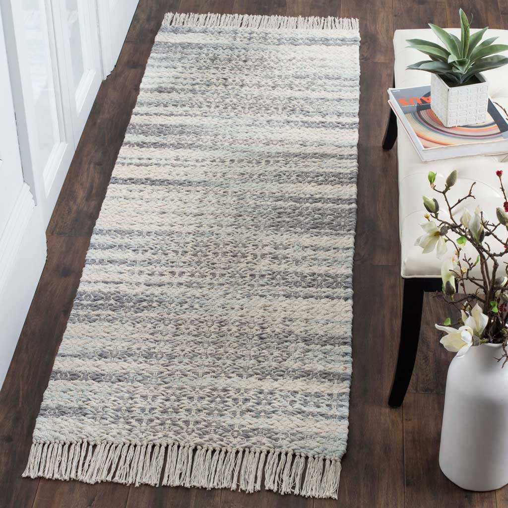 Textured gray and ivory runner adds a soft geometric accent and fringed detail to a hallway.
