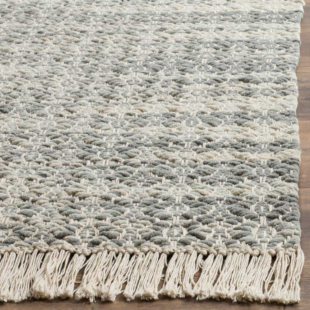 Thick gray and ivory cotton yarns meet a soft, generous fringe at the woven edge