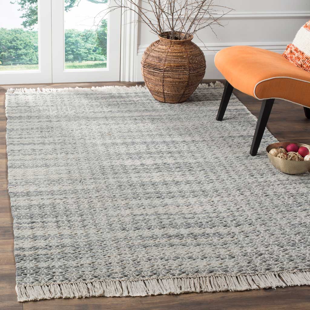 A low-profile gray and ivory cotton rug adds inviting woven texture and relaxed fringe